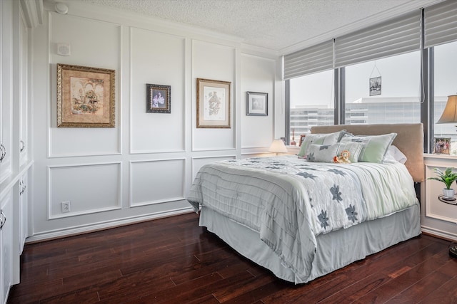 bedroom featuring a textured ceiling and dark hardwood / wood-style flooring