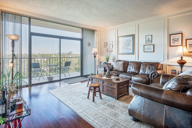 living room featuring ornamental molding, dark wood-type flooring, a wall of windows, and a textured ceiling