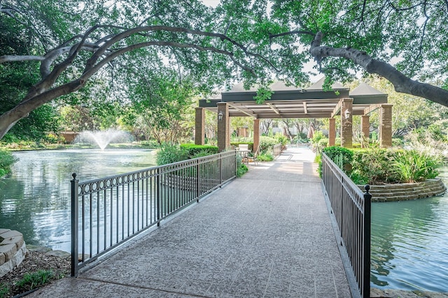 surrounding community featuring a water view and a pergola