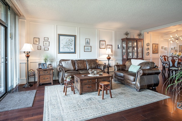 living room featuring ornamental molding, a notable chandelier, a textured ceiling, and dark hardwood / wood-style flooring