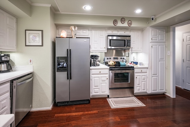 kitchen featuring appliances with stainless steel finishes, crown molding, dark hardwood / wood-style floors, and white cabinets