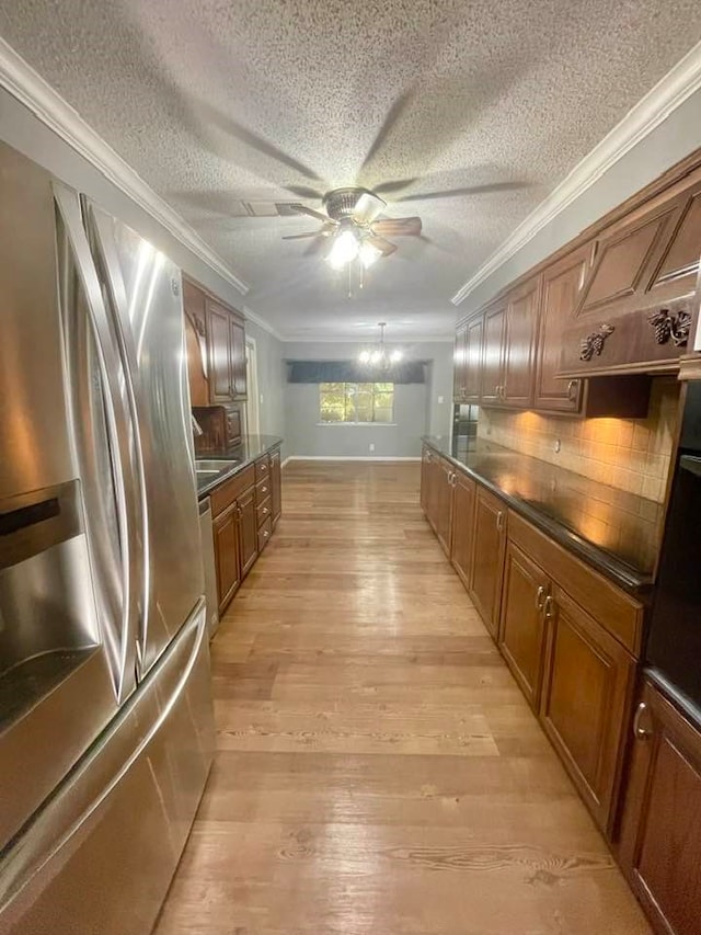 kitchen with ornamental molding, light hardwood / wood-style flooring, stainless steel fridge, and backsplash