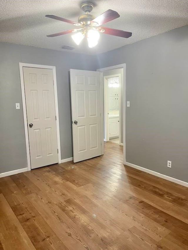 unfurnished bedroom featuring ceiling fan, a textured ceiling, and light hardwood / wood-style flooring