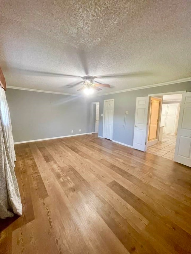 unfurnished bedroom featuring ornamental molding, light hardwood / wood-style flooring, a textured ceiling, and ceiling fan