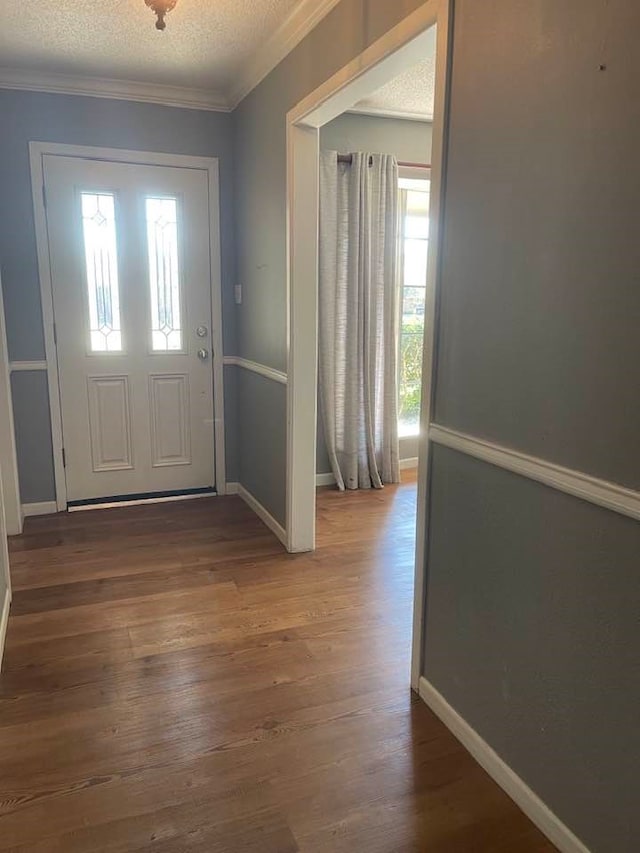 foyer featuring crown molding, a textured ceiling, and wood-type flooring