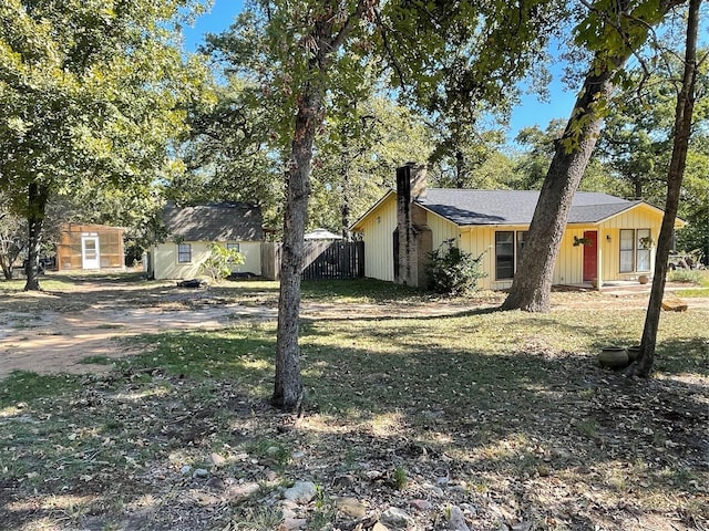 view of front of home with a shed and a front lawn