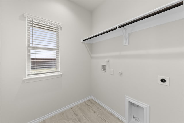 clothes washing area featuring electric dryer hookup, gas dryer hookup, light hardwood / wood-style floors, and washer hookup