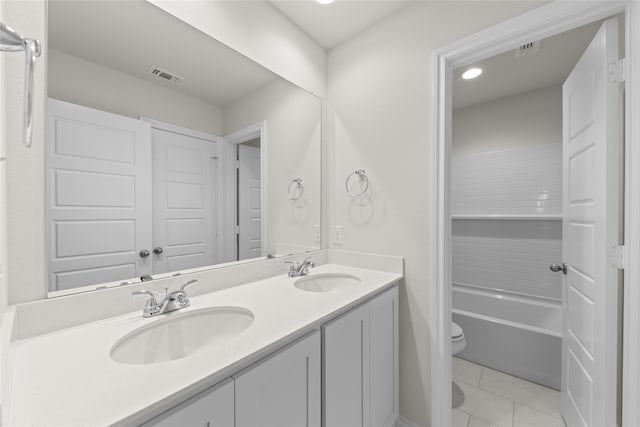 bathroom with toilet, vanity, and tile patterned floors