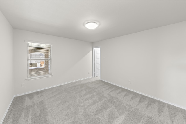 spare room featuring light colored carpet