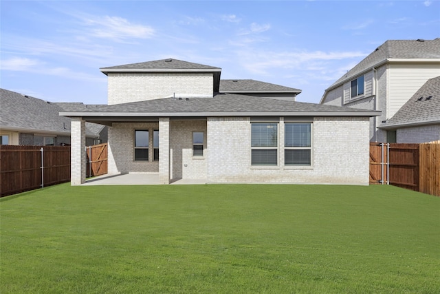 rear view of house with a patio area and a lawn