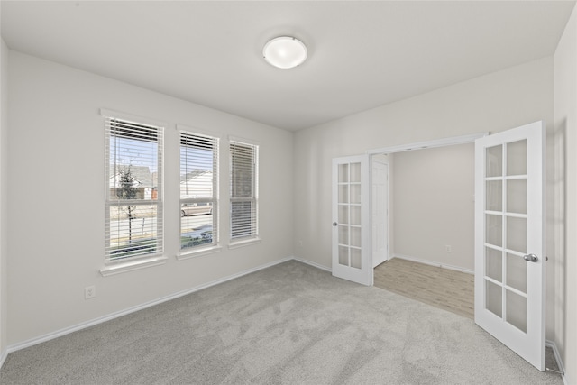 empty room with french doors and light colored carpet