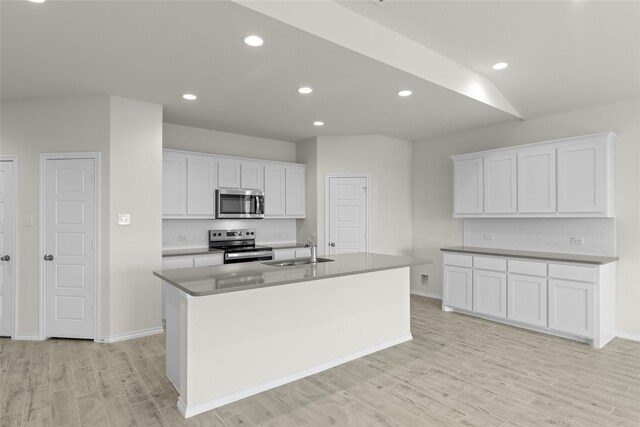 kitchen featuring sink, light hardwood / wood-style flooring, an island with sink, appliances with stainless steel finishes, and white cabinetry