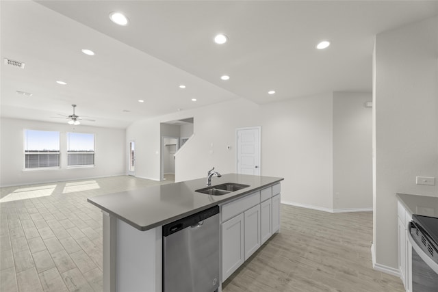 kitchen featuring stainless steel appliances, ceiling fan, sink, light hardwood / wood-style flooring, and an island with sink