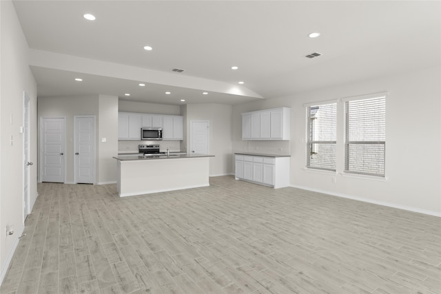 unfurnished living room with sink and light hardwood / wood-style flooring