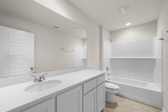 full bathroom featuring toilet, vanity,  shower combination, and hardwood / wood-style flooring