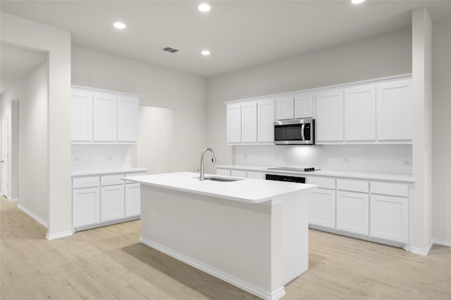 kitchen with white cabinetry, sink, and light hardwood / wood-style flooring