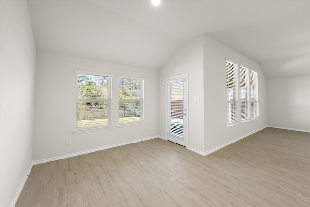 unfurnished room featuring light hardwood / wood-style floors and lofted ceiling