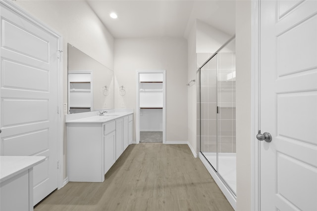 bathroom with hardwood / wood-style floors, vanity, and an enclosed shower