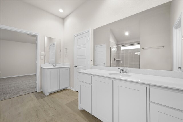 bathroom featuring vanity, wood-type flooring, and walk in shower