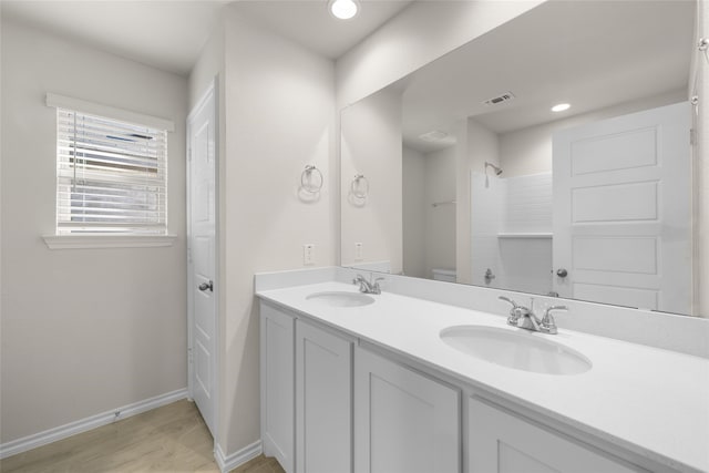 bathroom featuring toilet, hardwood / wood-style floors, vanity, and walk in shower