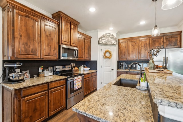 kitchen with hardwood / wood-style floors, appliances with stainless steel finishes, backsplash, pendant lighting, and sink