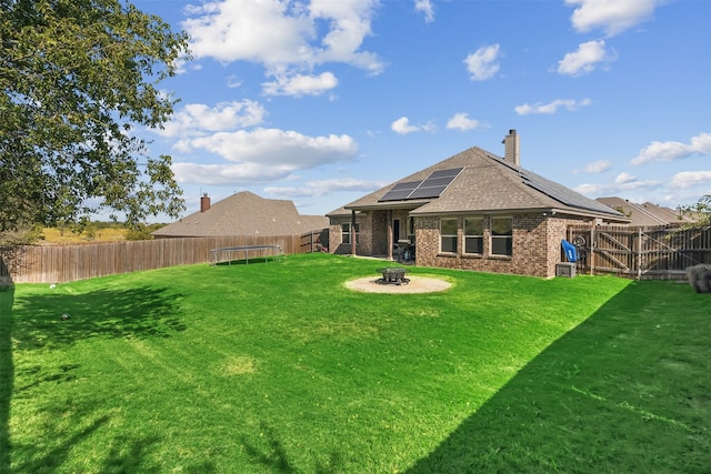 view of yard with an outdoor fire pit and a trampoline