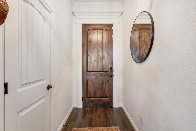 doorway to outside featuring crown molding and dark hardwood / wood-style floors