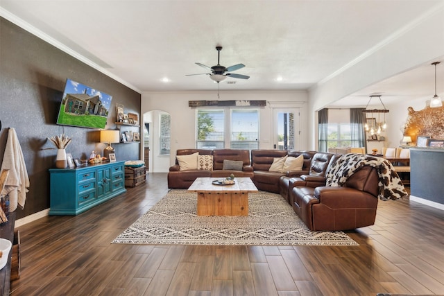 living room with ceiling fan with notable chandelier and crown molding