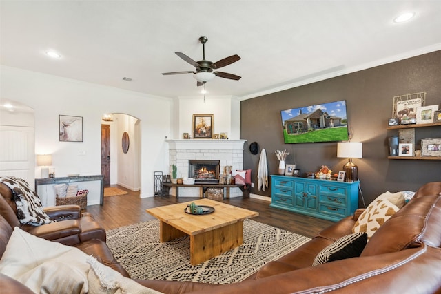 living room featuring ceiling fan, dark hardwood / wood-style flooring, and crown molding