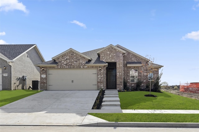 view of front of home featuring central air condition unit, a front yard, and a garage