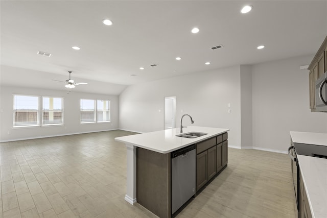 kitchen with lofted ceiling, sink, ceiling fan, an island with sink, and appliances with stainless steel finishes