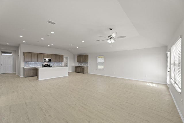 unfurnished living room with ceiling fan, light hardwood / wood-style floors, and sink