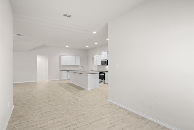 unfurnished living room featuring light hardwood / wood-style floors and sink