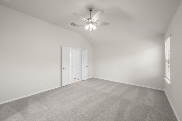 unfurnished bedroom with ceiling fan, lofted ceiling, and light carpet