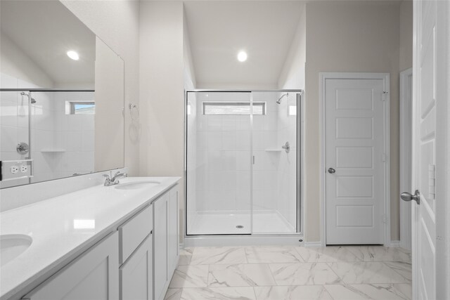 bathroom with a shower with shower door, vanity, lofted ceiling, and a wealth of natural light