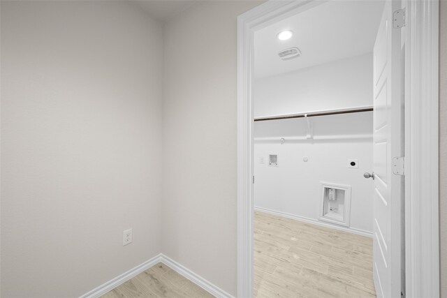 washroom featuring washer hookup, light hardwood / wood-style flooring, hookup for a gas dryer, and electric dryer hookup