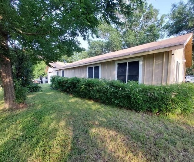 view of side of home with a lawn