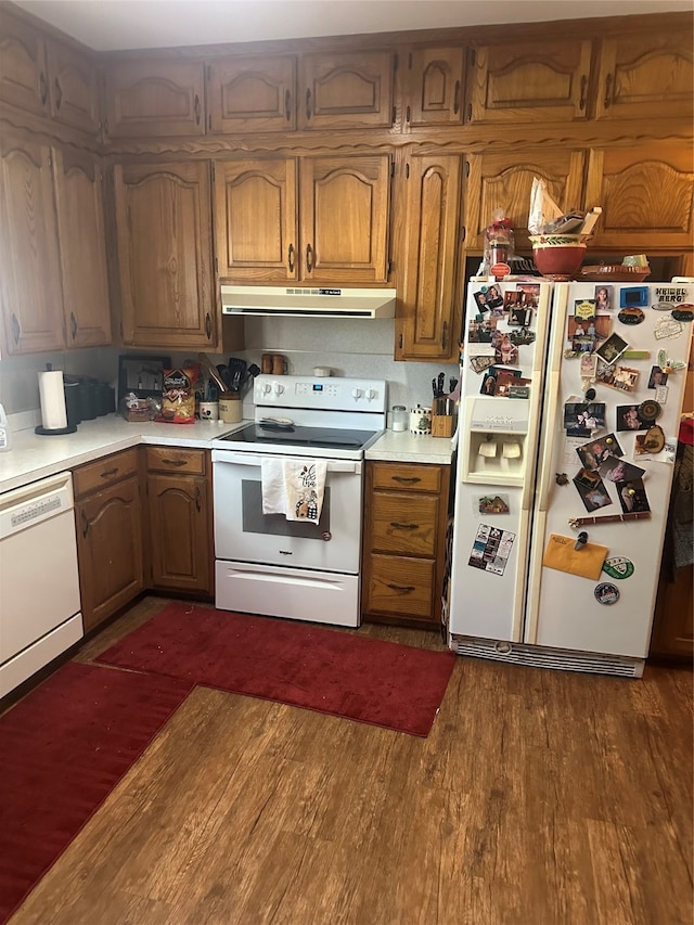 kitchen with white appliances and dark hardwood / wood-style floors