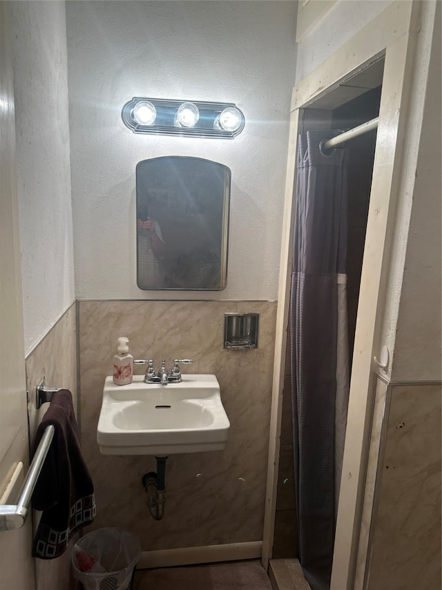 bathroom with tile walls and sink