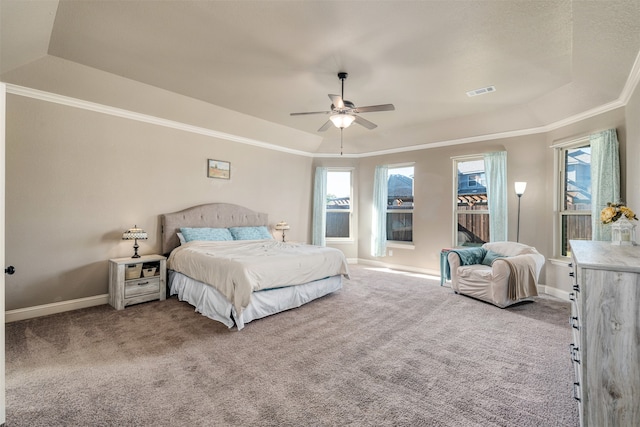 bedroom featuring a raised ceiling, multiple windows, ceiling fan, and carpet