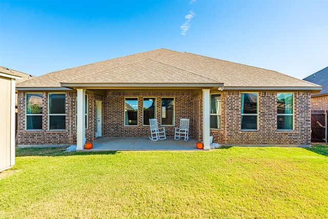 rear view of house featuring a lawn and a patio area