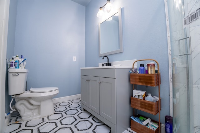 bathroom with a shower with door, vanity, and toilet