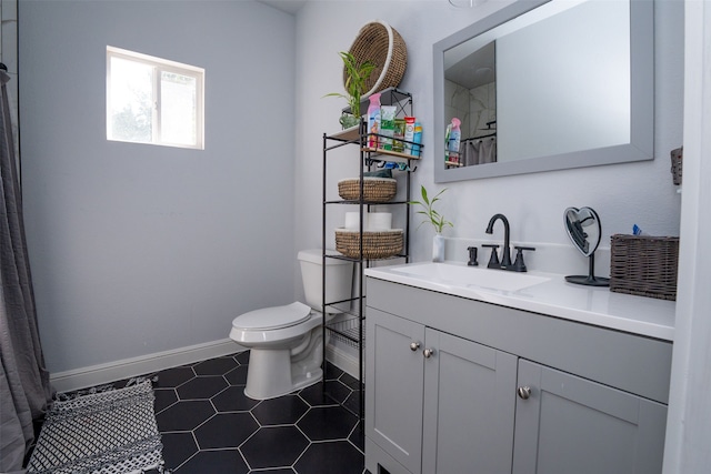 bathroom featuring toilet, walk in shower, vanity, and tile patterned floors