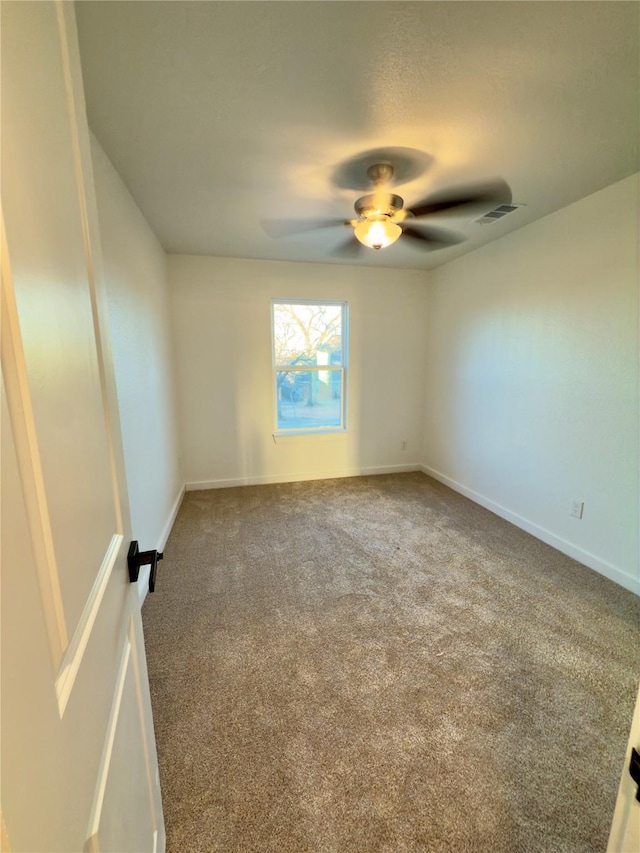 carpeted spare room with ceiling fan