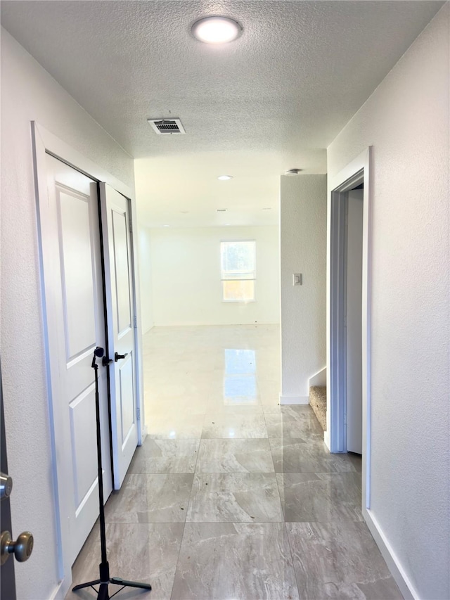 hallway with a textured ceiling