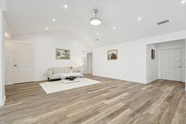 unfurnished living room with light hardwood / wood-style floors and lofted ceiling