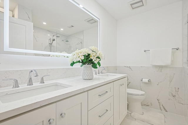 bathroom with a shower with door, toilet, tile walls, and vanity