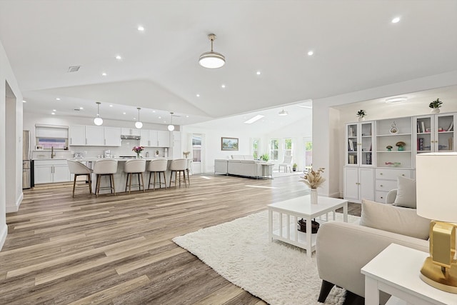 living room featuring vaulted ceiling and light hardwood / wood-style floors