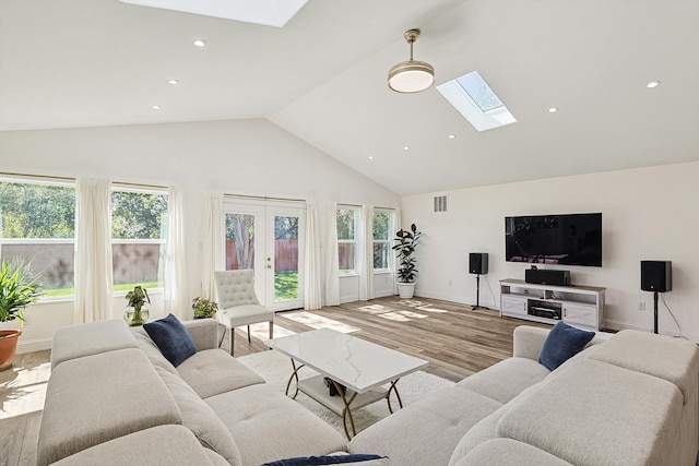 living room with light hardwood / wood-style flooring, french doors, high vaulted ceiling, and a wealth of natural light