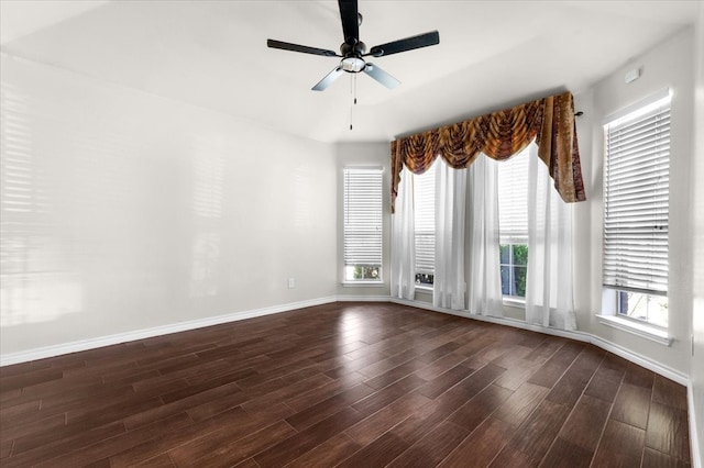 empty room featuring dark wood-type flooring, plenty of natural light, and ceiling fan